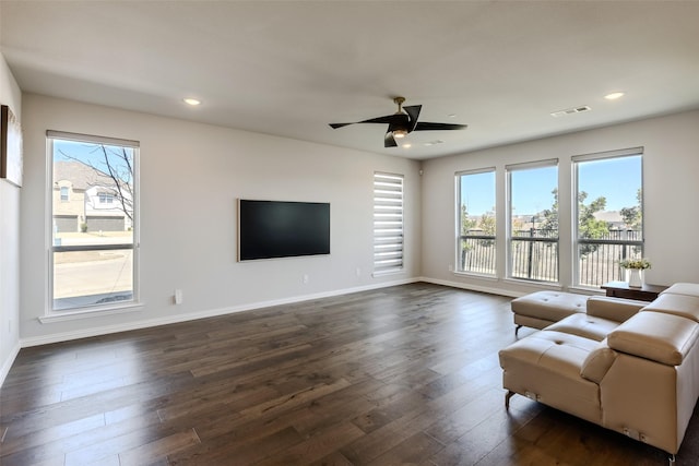 living area with recessed lighting, dark wood-style flooring, a wealth of natural light, and baseboards