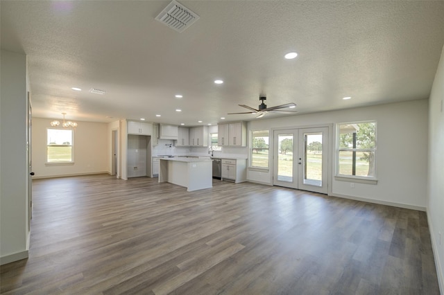 unfurnished living room with wood finished floors, visible vents, baseboards, recessed lighting, and a textured ceiling