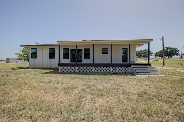 view of front of house with a front yard, a porch, and board and batten siding