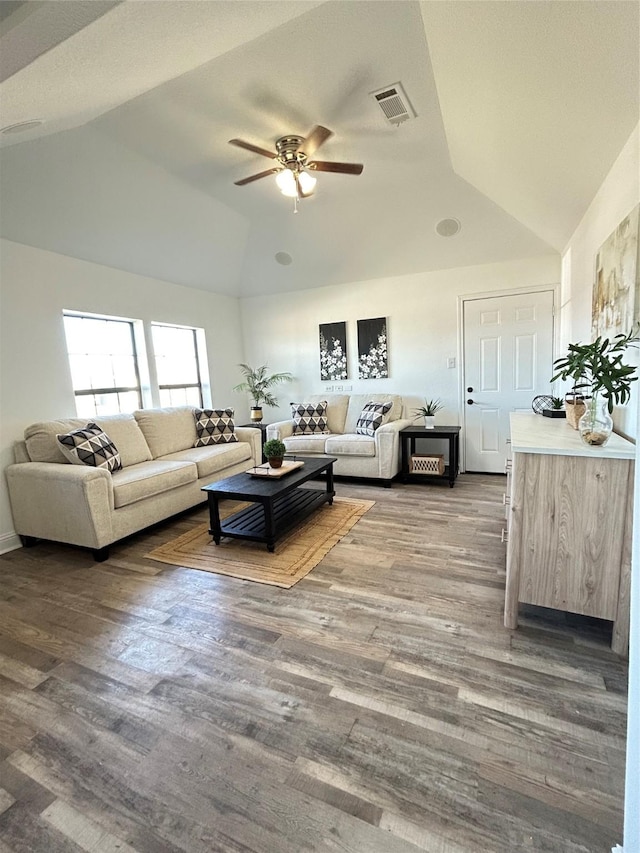 living area featuring visible vents, wood finished floors, a ceiling fan, and vaulted ceiling