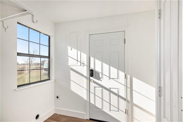 doorway to outside with baseboards and wood finished floors