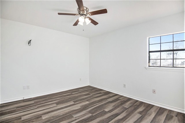 unfurnished room featuring dark wood finished floors, a ceiling fan, and baseboards