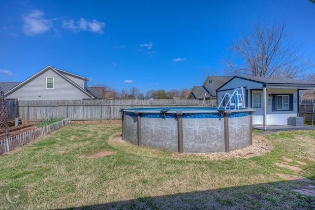 view of yard featuring central AC unit, a fenced in pool, and a fenced backyard