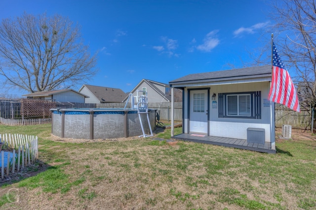 view of yard with a fenced in pool, an outdoor structure, and fence