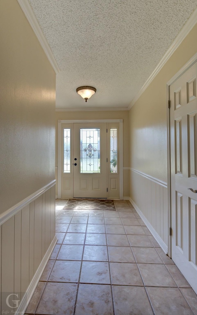 doorway featuring a wainscoted wall, a textured ceiling, and crown molding