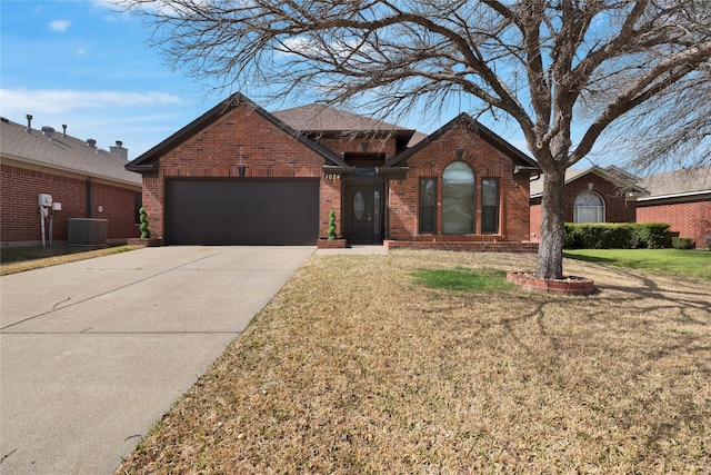 ranch-style home with concrete driveway, an attached garage, brick siding, and a front yard