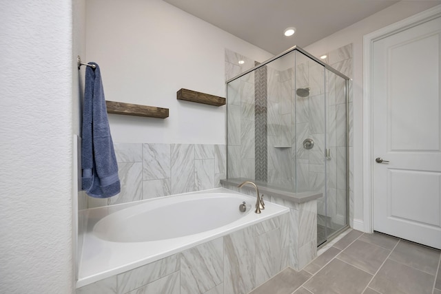 bathroom with tile patterned floors, a garden tub, and a shower stall