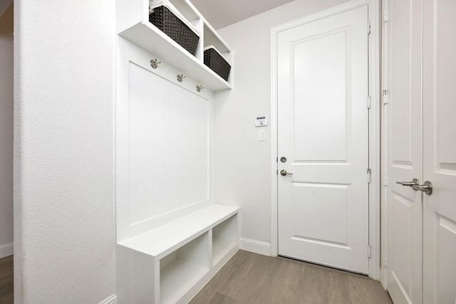 mudroom featuring wood finished floors and baseboards