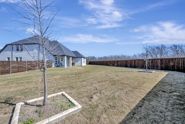 view of yard with a garden and a fenced backyard