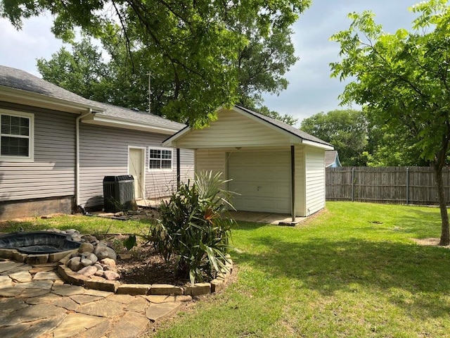 751 E Cooper St, Van Alstyne, TX 75495 - view of yard featuring cooling unit, a garage, and an outdoor fire pit