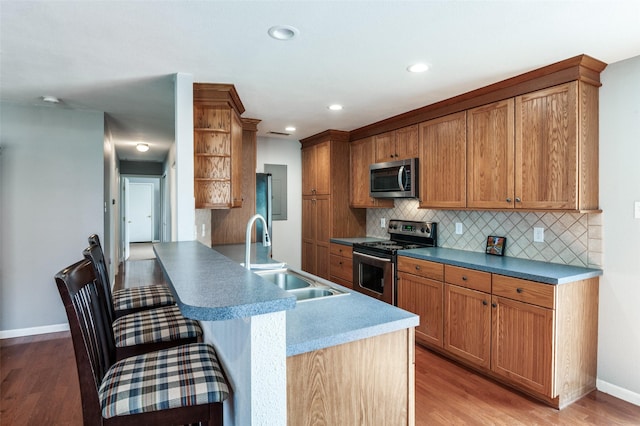 751 E Cooper St, Van Alstyne, TX 75495 - kitchen with appliances with stainless steel finishes, a sink, open shelves, decorative backsplash, and a kitchen breakfast bar