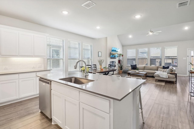 kitchen featuring a sink, visible vents, dishwasher, and light wood-style flooring