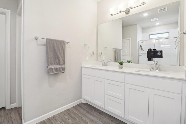 full bath featuring a sink, visible vents, baseboards, and a shower stall