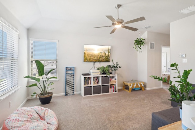 living area featuring visible vents, ceiling fan, baseboards, lofted ceiling, and carpet floors