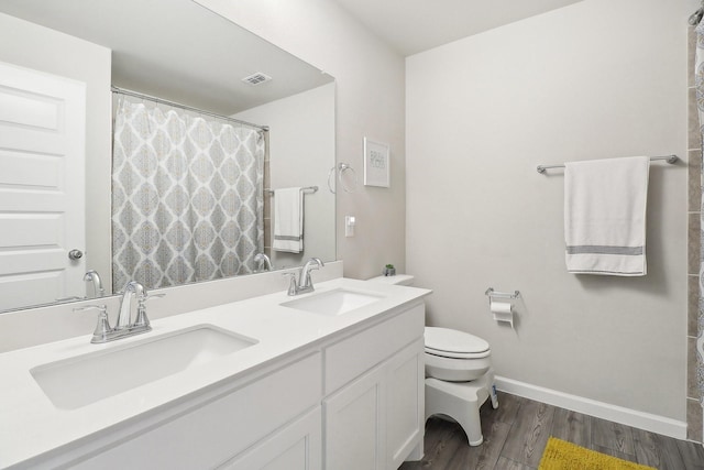 full bathroom with a sink, visible vents, toilet, and wood finished floors