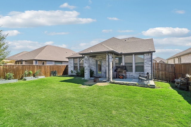 back of property featuring brick siding, a lawn, a patio, a fenced backyard, and a vegetable garden