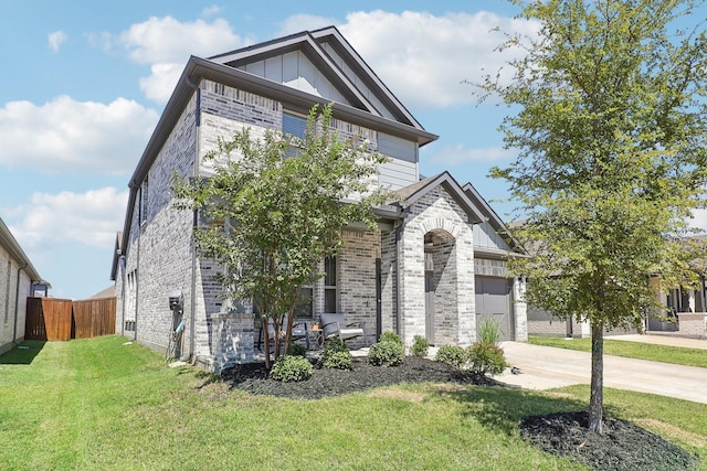 view of front of home featuring driveway, fence, board and batten siding, a front yard, and brick siding