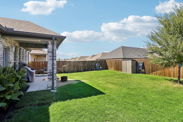 view of yard featuring an outdoor structure, a fenced backyard, and a patio area