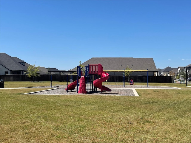 community jungle gym with a yard and fence