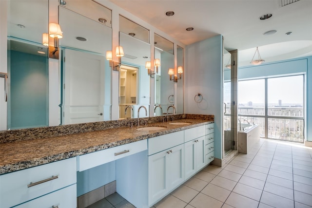 full bath featuring a bath, vanity, and tile patterned flooring