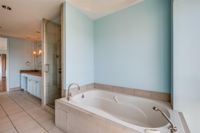 full bathroom with a garden tub, a shower stall, vanity, and tile patterned flooring