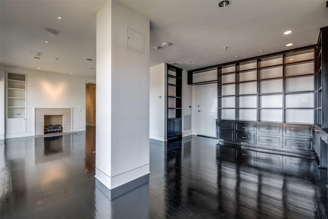 spare room with wood finished floors, visible vents, baseboards, recessed lighting, and a fireplace