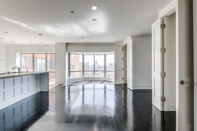 living area with recessed lighting, baseboards, dark wood finished floors, and a view of city