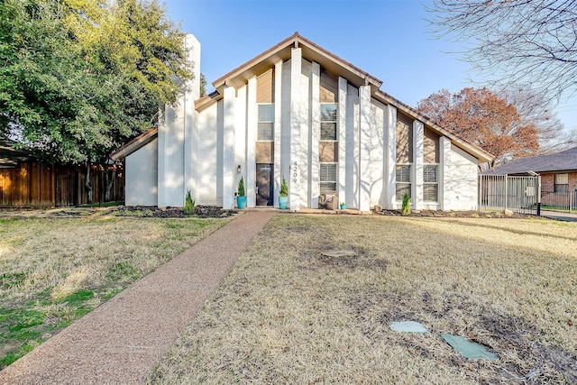 view of front facade with a front yard and fence