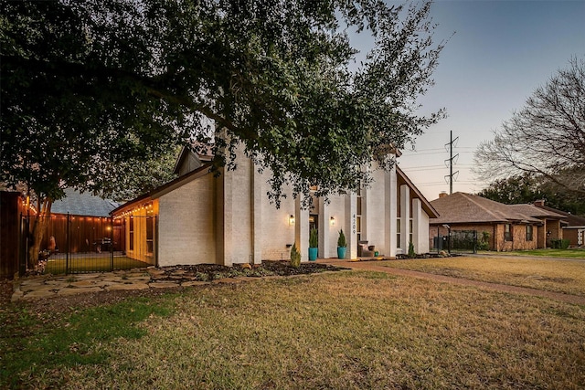 exterior space featuring stucco siding, a lawn, and fence