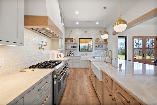 kitchen with a sink, double oven range, custom range hood, light wood-style floors, and open shelves