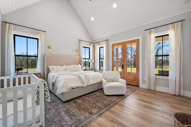 bedroom featuring french doors, multiple windows, access to outside, and light wood finished floors