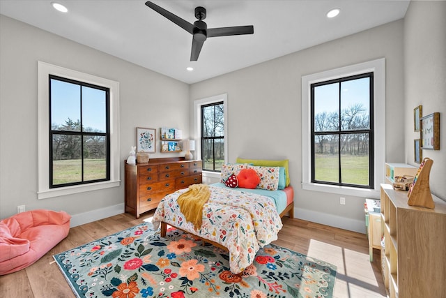 bedroom with recessed lighting, multiple windows, light wood-style flooring, and baseboards