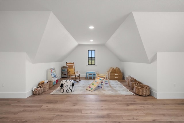 rec room featuring baseboards, lofted ceiling, and wood finished floors