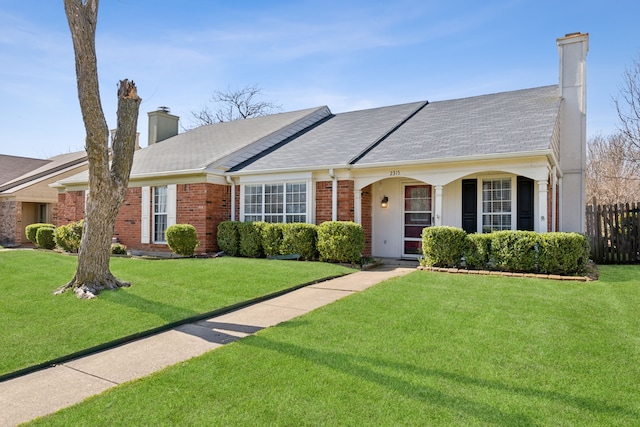 ranch-style home with brick siding, a chimney, a front yard, and fence