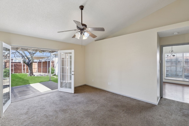 carpeted spare room with baseboards, a textured ceiling, lofted ceiling, and a ceiling fan