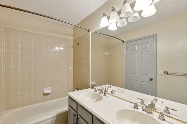 full bath with a sink, shower / bathing tub combination, a textured ceiling, and double vanity