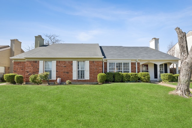 ranch-style house with a front lawn, brick siding, and a chimney