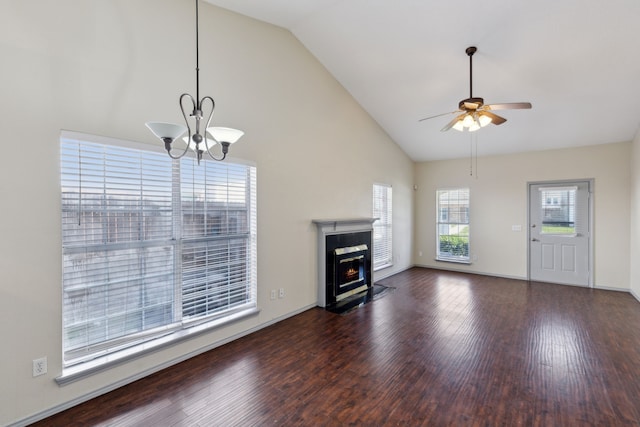 unfurnished living room with baseboards, a fireplace with flush hearth, ceiling fan with notable chandelier, high vaulted ceiling, and dark wood-style flooring