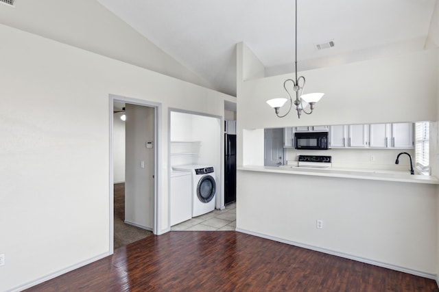 kitchen with visible vents, independent washer and dryer, black appliances, lofted ceiling, and a chandelier