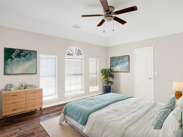 bedroom with visible vents, baseboards, dark wood-style floors, and a ceiling fan