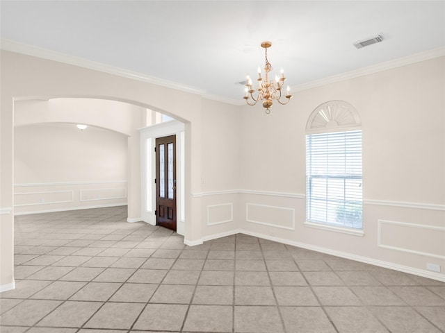 spare room featuring arched walkways, visible vents, a decorative wall, and a notable chandelier