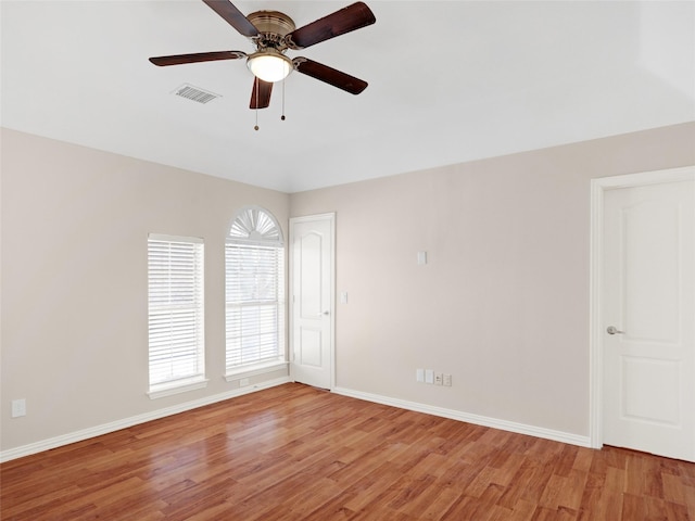 spare room featuring visible vents, light wood-style flooring, baseboards, and a ceiling fan