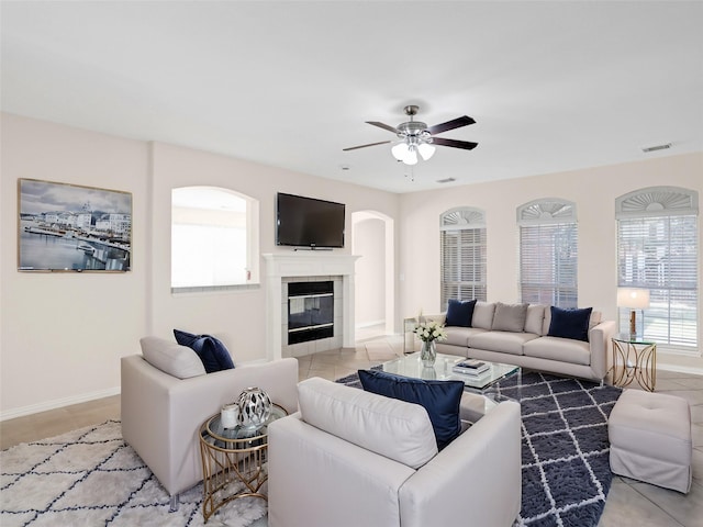 living area featuring visible vents, a ceiling fan, light tile patterned flooring, a fireplace, and baseboards