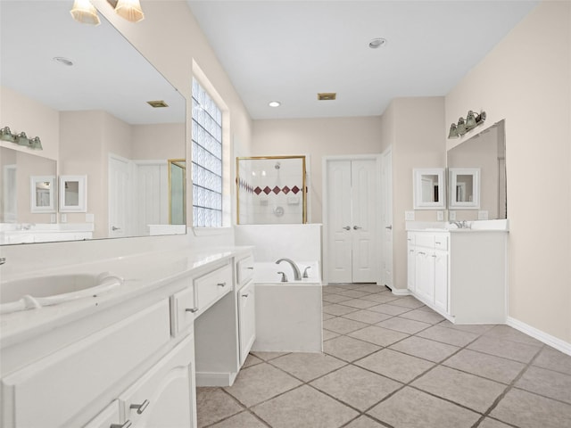 full bathroom featuring tile patterned flooring, a shower stall, a garden tub, two vanities, and a sink