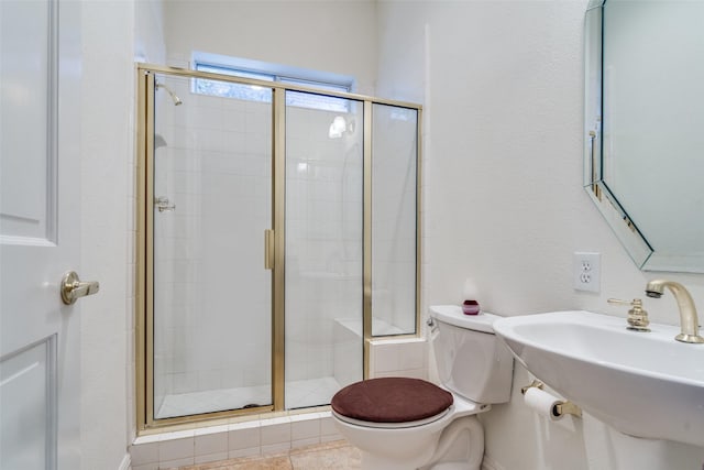 bathroom featuring a sink, toilet, and a shower stall