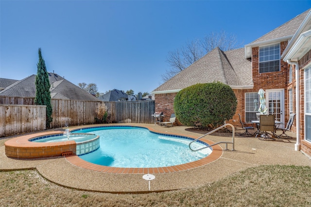 view of swimming pool with a patio area, a fenced backyard, and a pool with connected hot tub