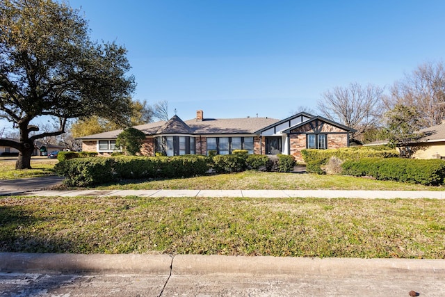 view of front of home with a front lawn and a chimney