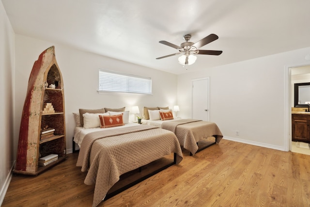 bedroom with light wood-style flooring, ensuite bath, baseboards, and ceiling fan