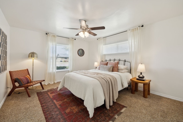 carpeted bedroom with baseboards, multiple windows, and a ceiling fan