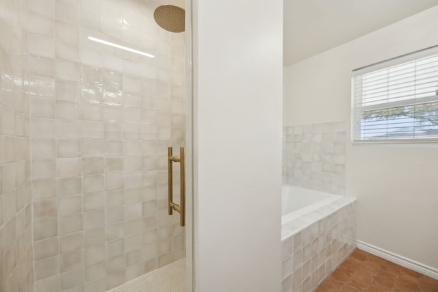 bathroom featuring tile patterned floors, baseboards, tiled shower, and a garden tub